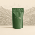 Sachet de café KÚPS Zomboambe sur un décor de collines tropicales de Zombo en Ouganda